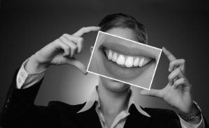 Frau hält Foto von gesunden Zähnen